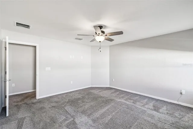 a view of a white house with a ceiling fan