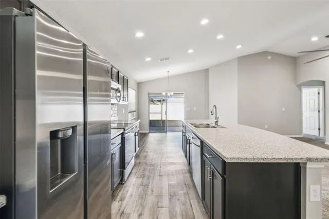 a kitchen with stainless steel appliances granite countertop a sink and stove