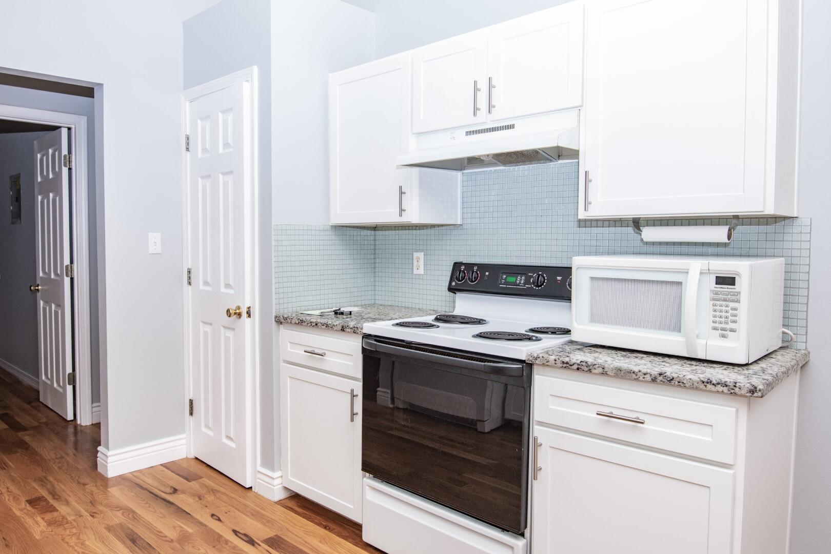 607 Risen Star Drive Crestview, FL 32539 - Photo 17 of 35 a kitchen with granite countertop white cabinets and white appliances