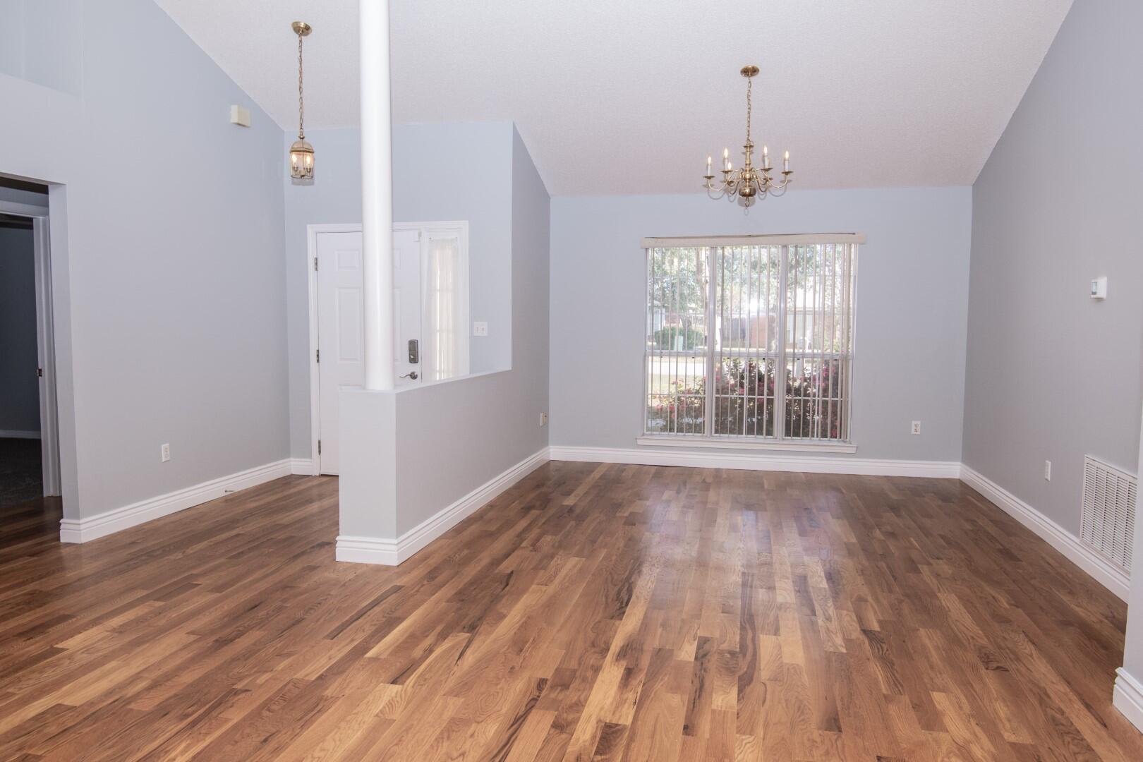 607 Risen Star Drive Crestview, FL 32539 - Photo 5 of 35 a view of an empty room with wooden floor and a window