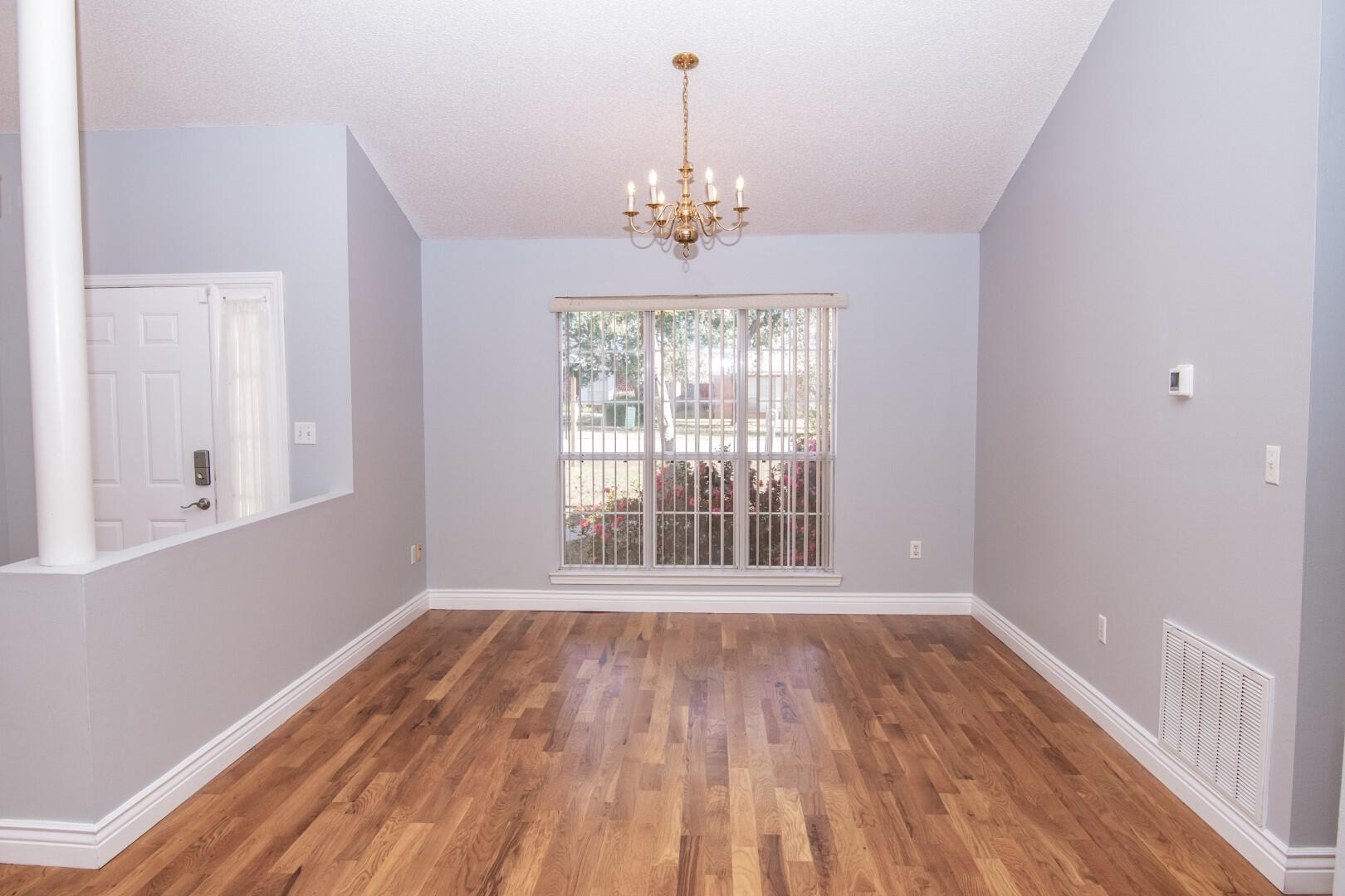 607 Risen Star Drive Crestview, FL 32539 - Photo 6 of 35 a view of an empty room with wooden floor and a window