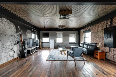 a living room with lots of furniture and kitchen view