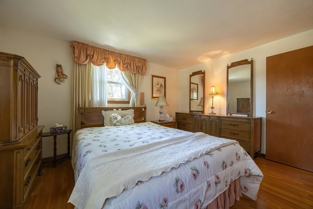 21 Trinity Drive Milford, MA 01757 - Photo 19 of 38 a bedroom with a bed a dresser and wooden floor