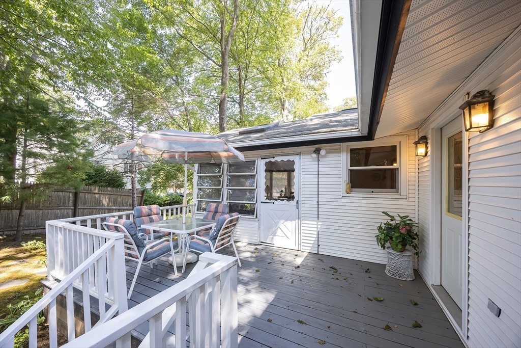 21 Trinity Drive Milford, MA 01757 - Photo 31 of 38 a view of a patio with table and chairs with wooden floor and fence