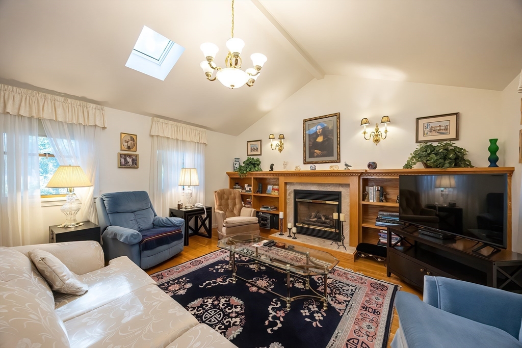 21 Trinity Drive Milford, MA 01757 - Photo 9 of 38 a living room with furniture a fireplace and a flat screen tv