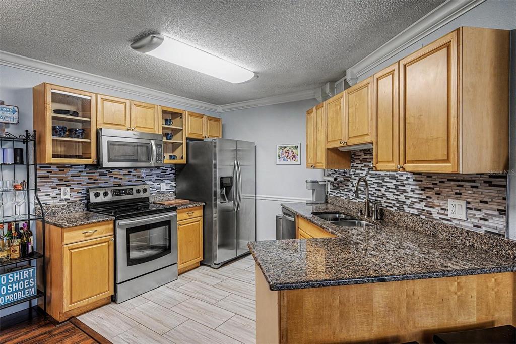 1550 South Belcher Road, Unit 525 Clearwater, FL 33764 - Photo 10 of 28 a kitchen with stainless steel appliances granite countertop a stove a sink and a microwave