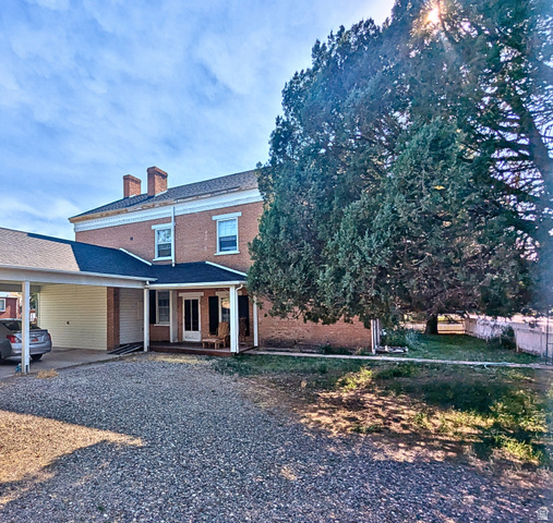 190 North 200 E Street Beaver, UT 84713 - Photo 8 of 40 Brick exterior home featuring a covered porch, a carport, and twin chimneys
