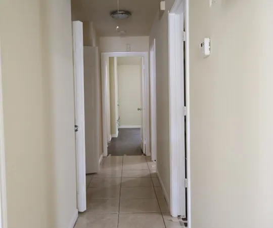 a view of a hallway with closet and a bathroom