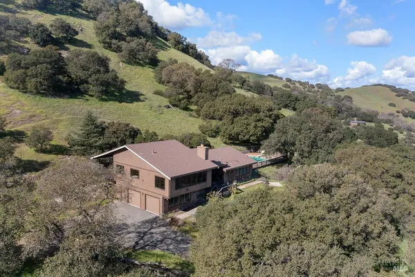an aerial view of a house with yard and mountain view
