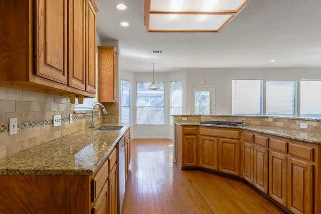 a large kitchen with granite countertop a lot of counter space and wooden floor