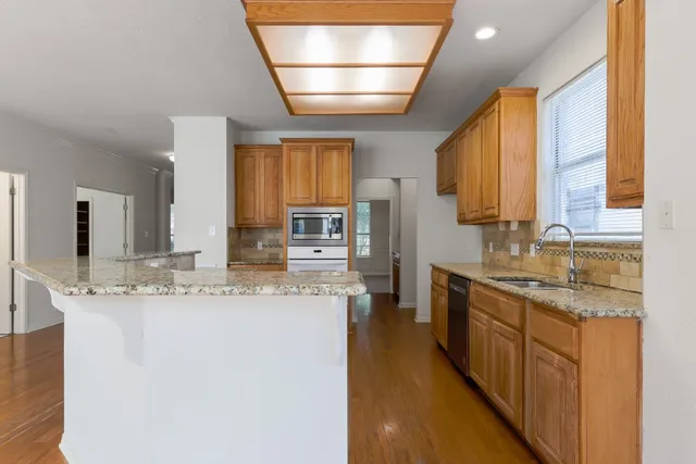 a large kitchen with kitchen island granite countertop a sink window and cabinets
