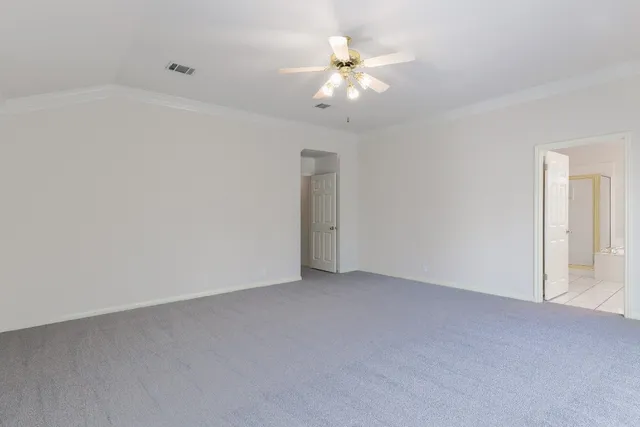 an empty room with a chandelier fan
