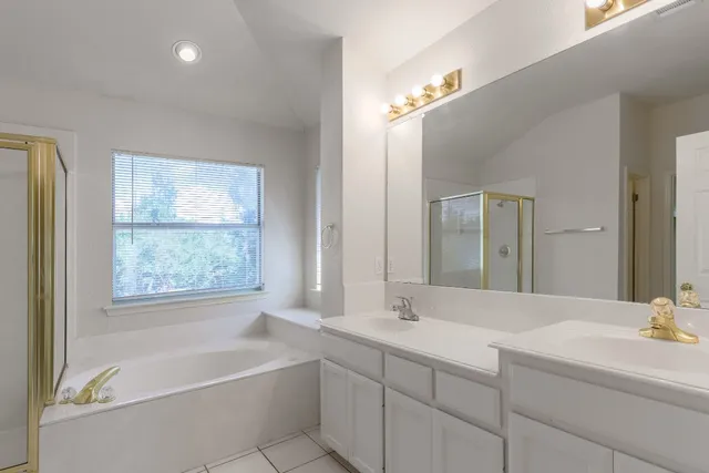 a bathroom with a large tub sink and vanity