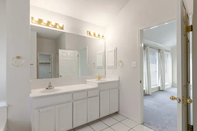 a bathroom with a double vanity sink and mirror with shower
