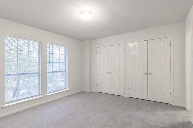 an empty room with windows and closet