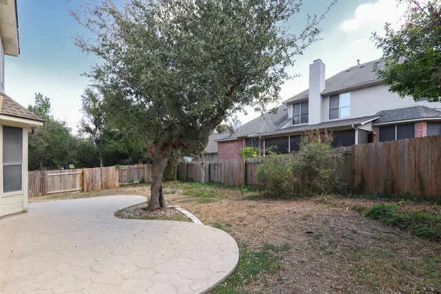 a view of a house with backyard and tree