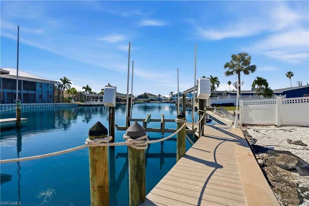 1 Fairview Boulevard Fort Myers Beach, FL 33931 - Photo 27 of 48 Private dock featuring a boat lift, sturdy pilings, and a rope railing - Virtually Edited Image