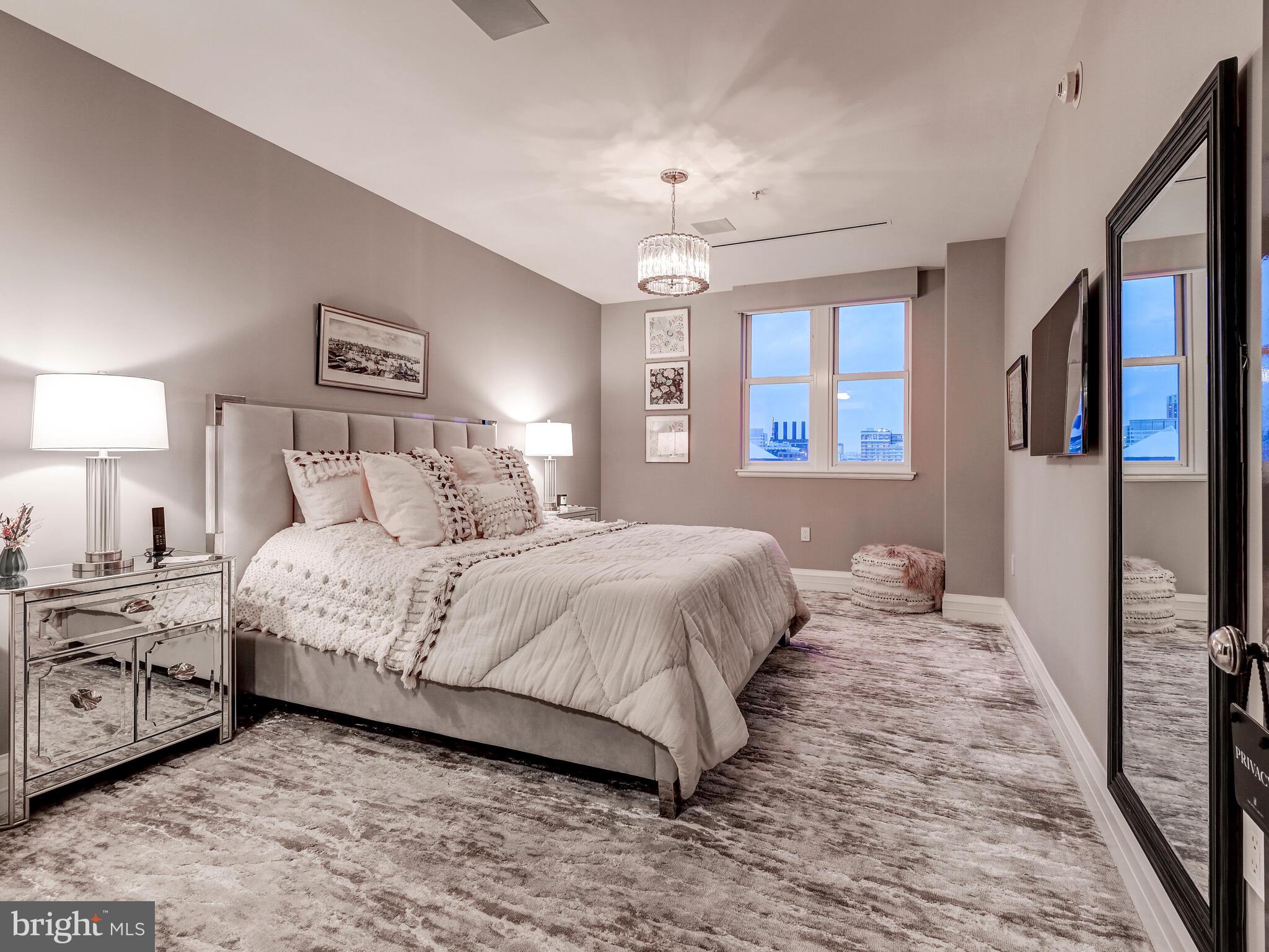 801 Key Highway, Unit P54 Baltimore, MD 21230 - Photo 48 of 81 a bedroom with a large bed and a chandelier