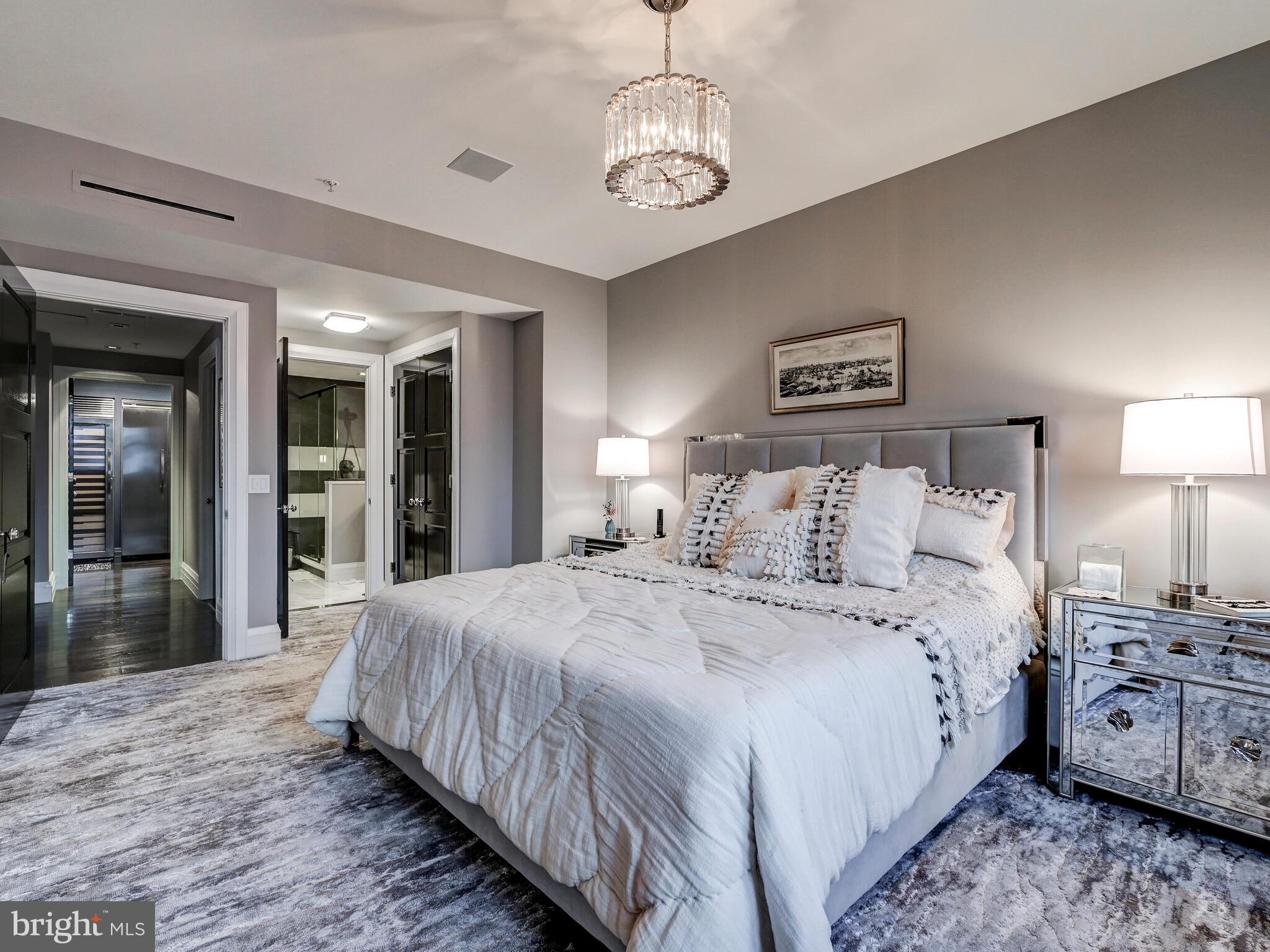 801 Key Highway, Unit P54 Baltimore, MD 21230 - Photo 49 of 81 a spacious bedroom with a large bed and a chandelier