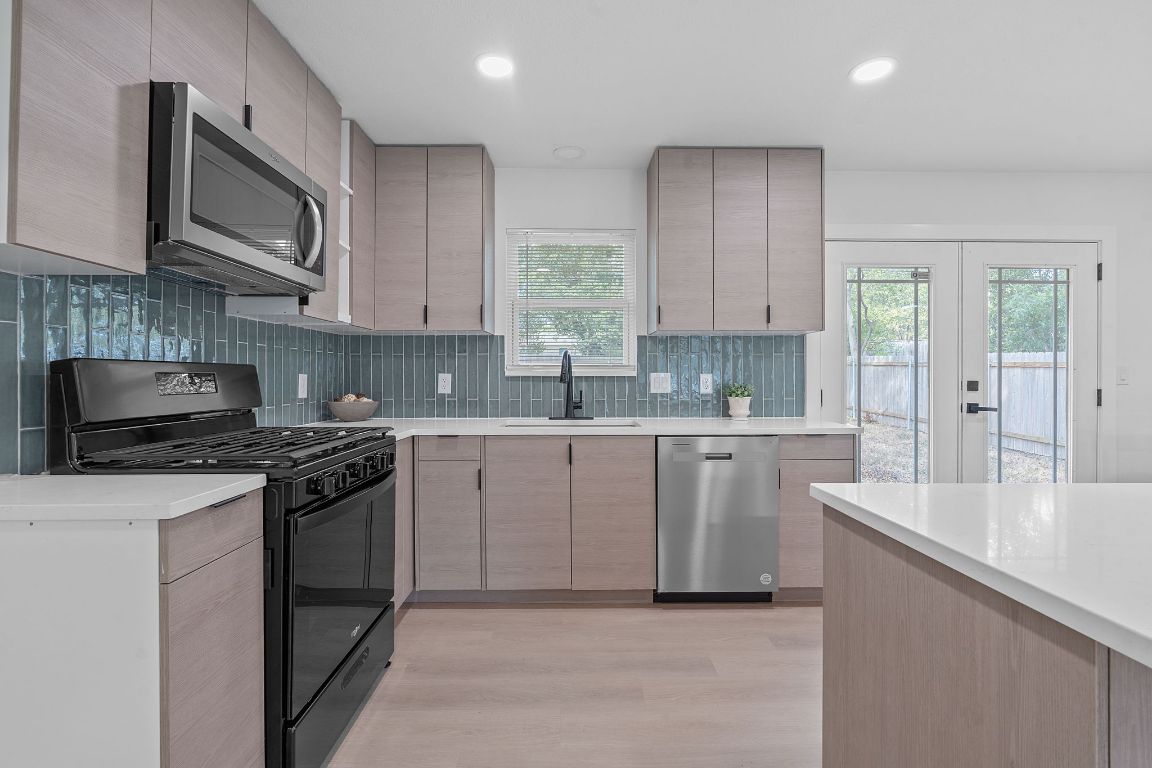 a kitchen with stainless steel appliances granite countertop a stove sink microwave and cabinets