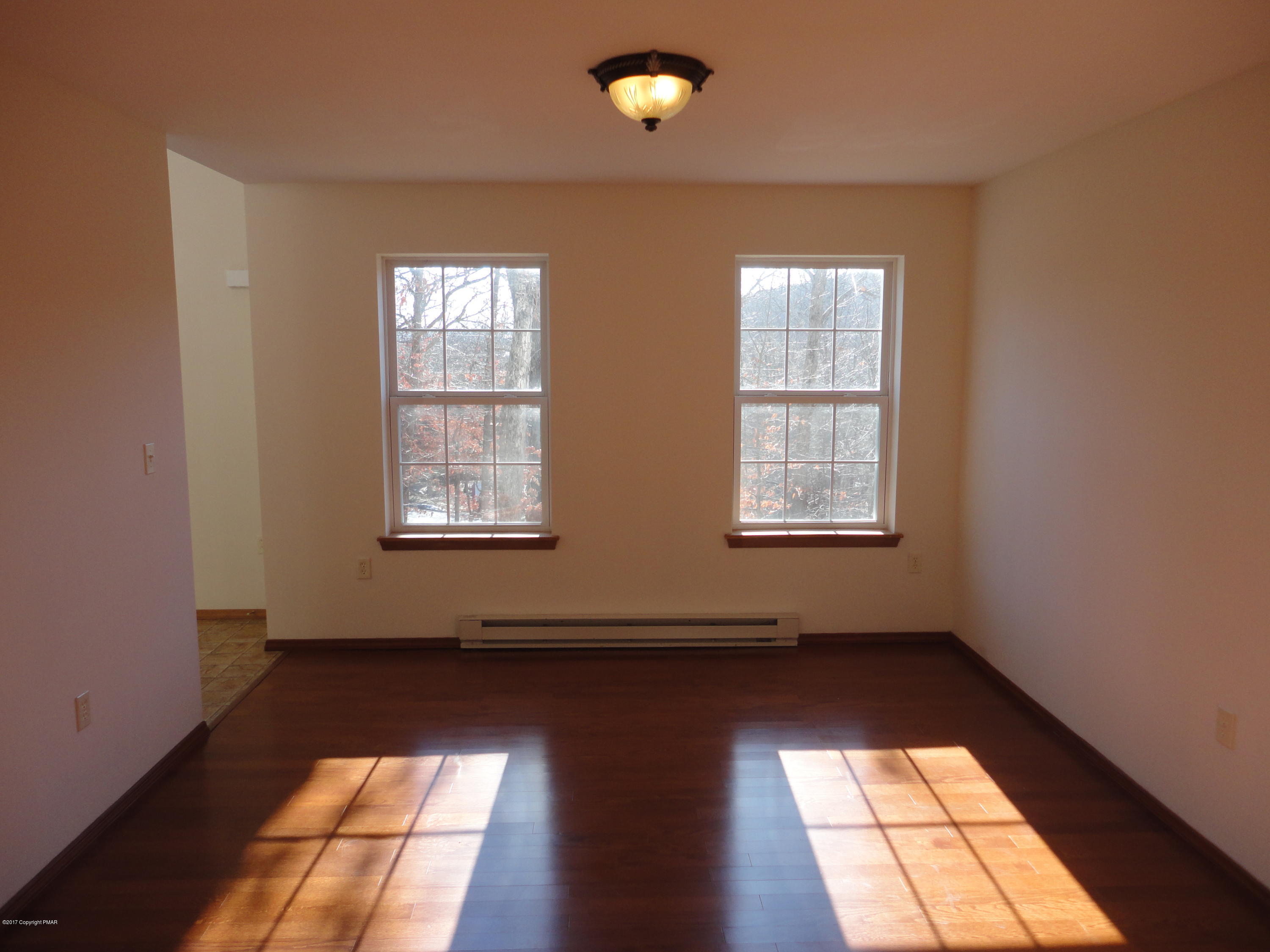 6389 Decker Road Bushkill, PA 18324 - Photo 5 of 22 a view of an empty room with wooden floor and a window