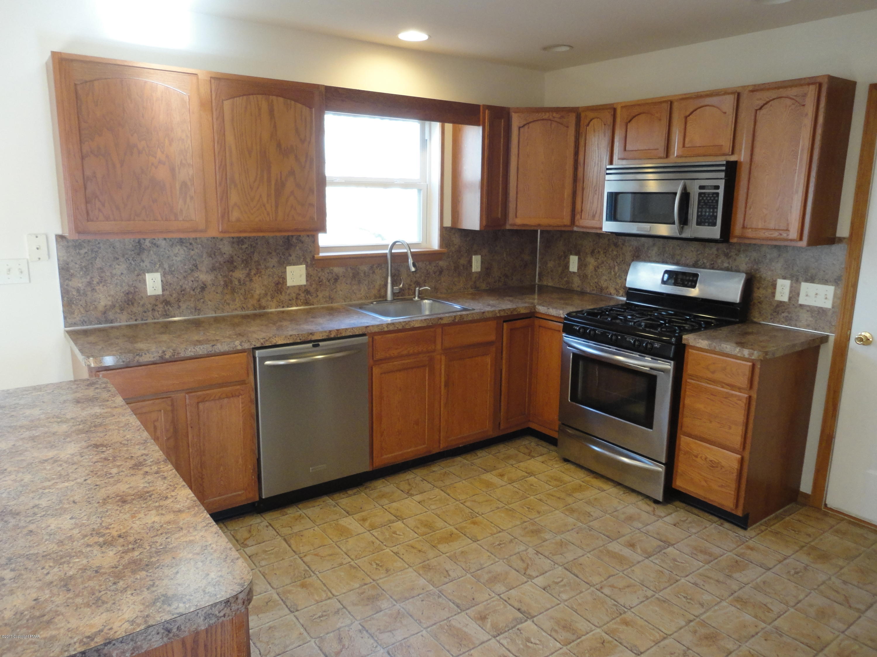 6389 Decker Road Bushkill, PA 18324 - Photo 9 of 22 a kitchen with stainless steel appliances granite countertop a stove microwave and sink