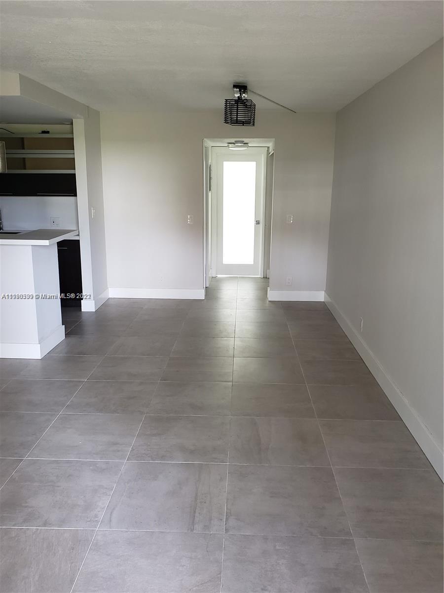 384 Mansfield I, Unit 384 Boca Raton, FL 33434 - Photo 3 of 9 a view of an empty room with a fireplace and a window
