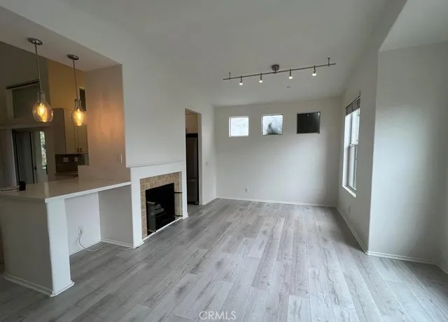 an empty room with wooden floor and fireplace