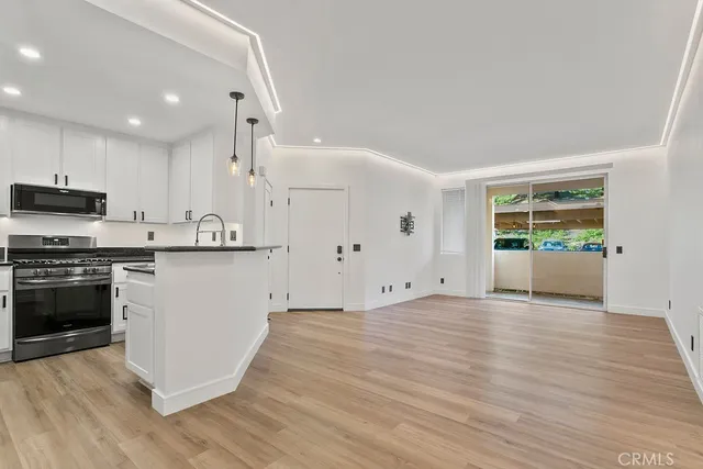 a view of kitchen with wooden floor and electronic appliances