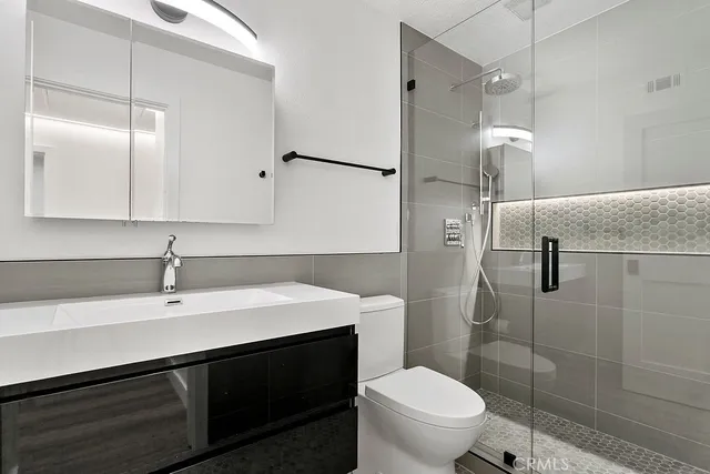 a bathroom with a sink a toilet and shower