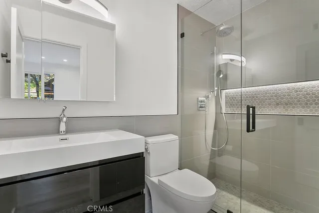 a bathroom with a sink a toilet and shower