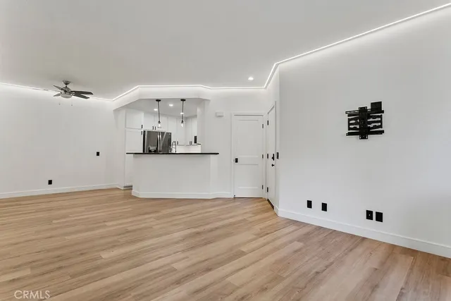 a view of a room with wooden floor and white walls