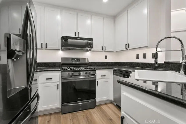 a kitchen with stainless steel appliances granite countertop a stove a refrigerator and a microwave