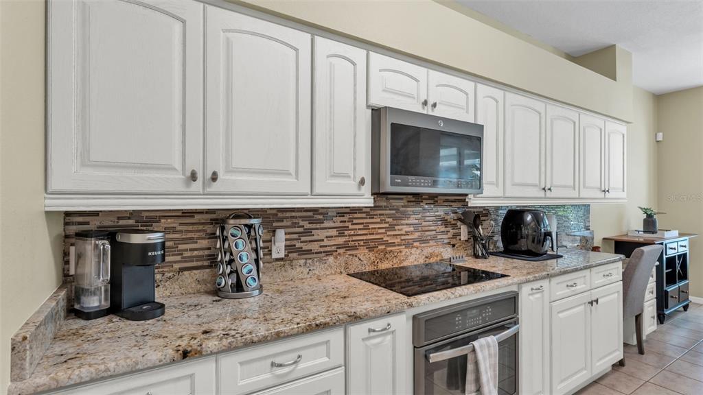 2803 Spring Meadow Drive Plant City, FL 33566 - Photo 17 of 74 a kitchen with granite countertop white cabinets and white appliances
