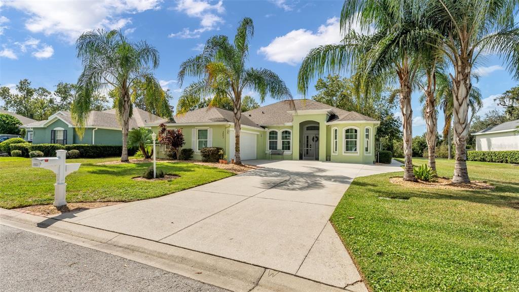 2803 Spring Meadow Drive Plant City, FL 33566 - Photo 2 of 74 a front view of a house with a yard and palm trees