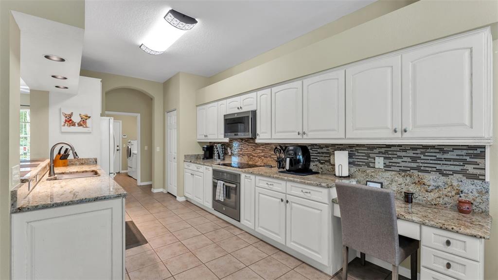 2803 Spring Meadow Drive Plant City, FL 33566 - Photo 21 of 74 a kitchen with granite countertop white cabinets and white appliances