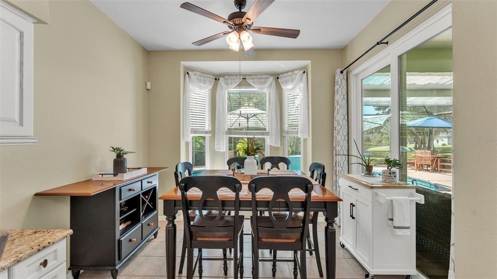 2803 Spring Meadow Drive Plant City, FL 33566 - Photo 23 of 74 a view of a dining room with furniture large windows and wooden floor