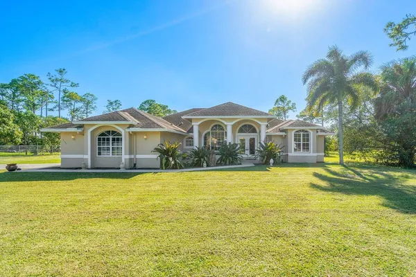 a front view of house with yard and swimming pool