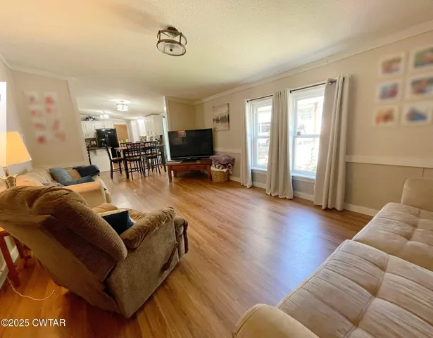 a living room with furniture and a flat screen tv with wooden floor