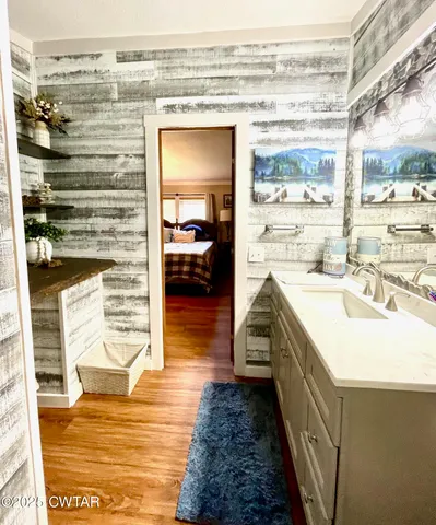 a bathroom with a sink a mirror and next to a window