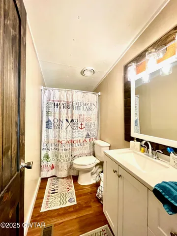 a bathroom with a sink toilet a mirror and shower