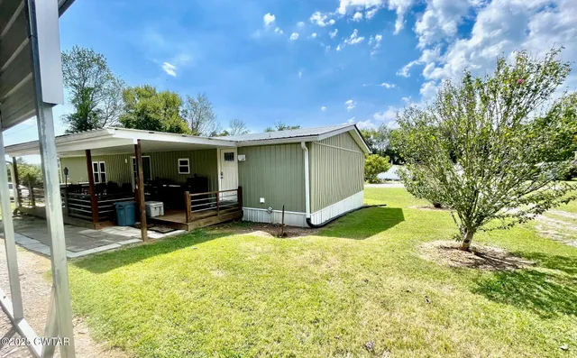a view of a house with a backyard and a patio