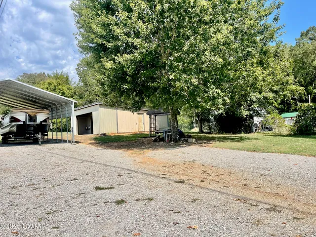 a view of a yard with a house and a tree