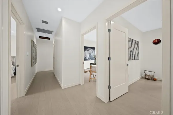 a view of a hallway with refrigerator and cabinet