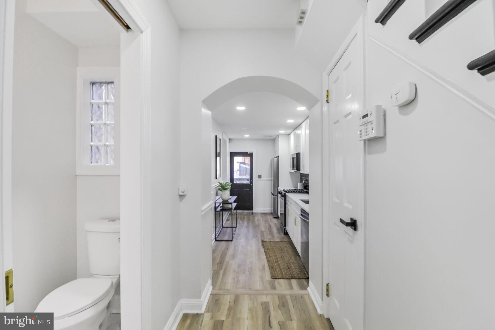 226 South Madeira Street Baltimore, MD 21231 - Photo 6 of 21 a view of a hallway with bathroom and wooden floor
