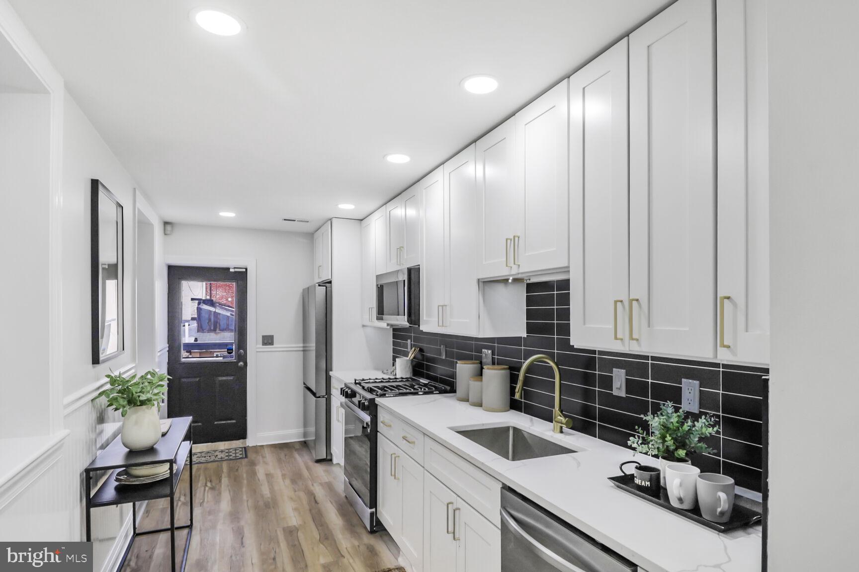 226 South Madeira Street Baltimore, MD 21231 - Photo 8 of 21 a kitchen with granite countertop a sink stainless steel appliances and cabinets