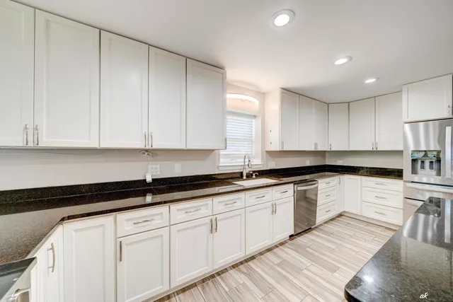 a kitchen with granite countertop white cabinets and white appliances