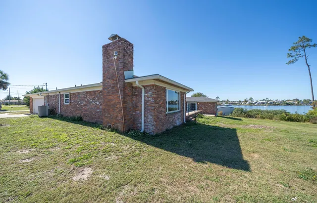 a view of a house with backyard and a tree
