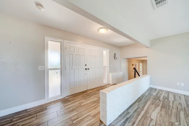 a view of empty room with wooden floor