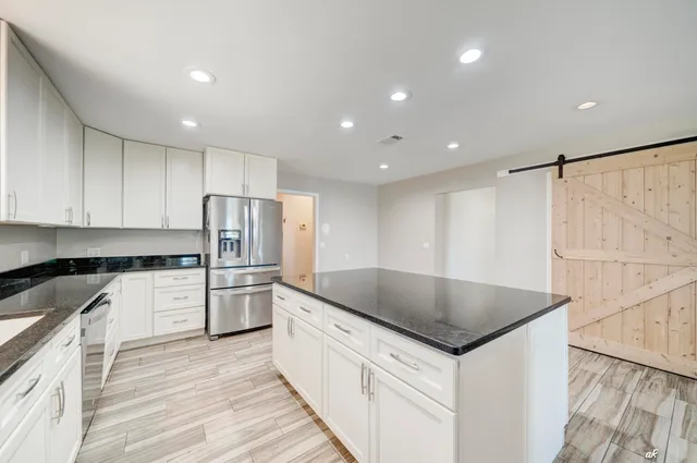 a kitchen with granite countertop a sink and a stove top oven